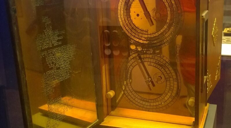 Modern reconstruction of the Antikythera Mechanism displayed in a museum, showing its front and rear astronomical dials.